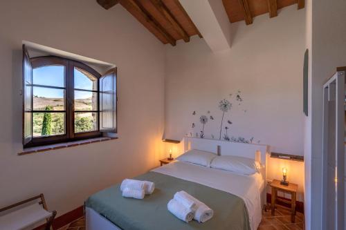 a bedroom with a bed with two towels on it at Podere Fossaccio Casa Fiordaliso in Asciano