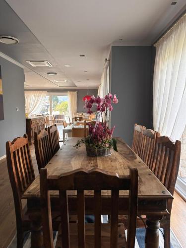 a dining room with a wooden table with flowers on it at Bes Hotel Terme a Palazzago in Palazzago