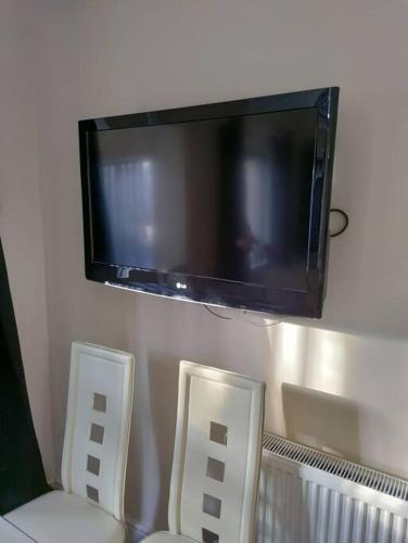 two chairs and a tv hanging on a wall at Droitwich Spa centre apartment in Droitwich