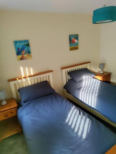 two beds in a bedroom with blue sheets at Droitwich Spa centre apartment in Droitwich