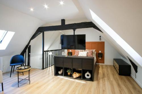 a loft conversion with a living room with a tv at Le Cocon in Cambrai