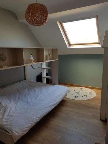 une chambre avec un grand lit et une fenêtre dans l'établissement Au gré du vent, à Wimereux