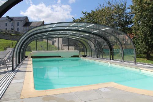 una piscina con un puente de cristal sobre ella en Le grenier de la Floye en Biesmerée