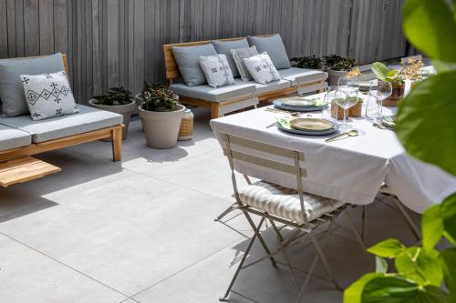 een patio met een tafel, banken en planten bij B&B Summertime in Koksijde