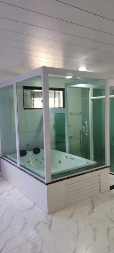 a large bathroom with a tub in a glass enclosure at Pousada Hotel Lumiar in Lumiar