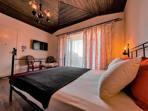 a bedroom with a large bed with a large window at Assos Longevity Hotel in Sokakagzi