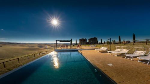 a swimming pool with chairs and the sun in the sky at Podere Fossaccio Casa Olivo in Asciano