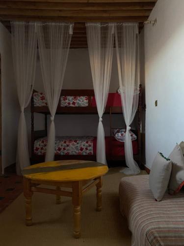 a room with a bed and a table and curtains at Tarbi'aat Tetaoun 44, 17th century heritage in Tetouan