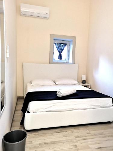 een wit bed in een kamer met een raam bij Dietro Piazza Duomo in Acireale