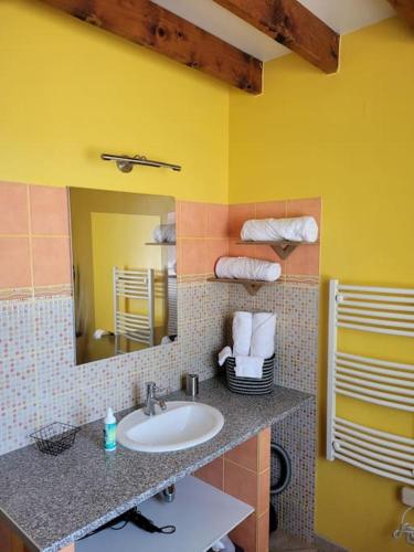 une salle de bain avec un lavabo et un miroir dans l'établissement Le Charme Normand, à Norville