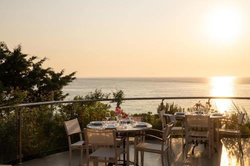 a table and chairs on a balcony overlooking the ocean at Mare Dei Suites Hotel Ionian Resort in Skafidia