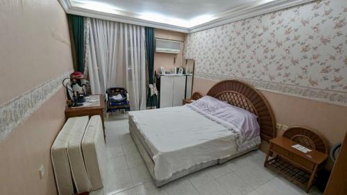 a bedroom with a bed and a table and a refrigerator at Luxury House by the Sea Marmaris in Marmaris