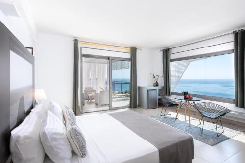 a bedroom with a bed and a view of the ocean at Mare Dei Suites Hotel Ionian Resort in Skafidia