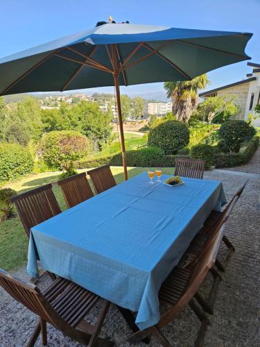 a table with a blue table cloth and an umbrella at Casa das Acácias in Cabeceiras de Basto