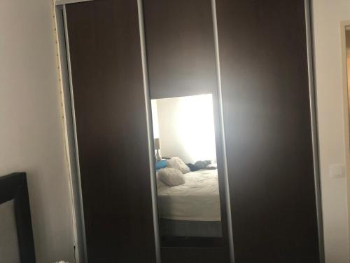 - un placard avec un miroir et un lit dans une chambre dans l'établissement Chambre privée confortable à louer chez l habitant proche plage et centre ville de Nice, à Nice