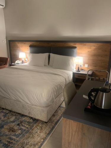 a bedroom with a bed and two tables and two lamps at نوفا بارك للشقق المخدومة in Sharurah
