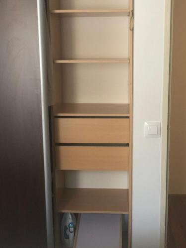 a closet with wooden shelves in a room at Chambre privée confortable à louer chez l habitant proche plage et centre ville de Nice in Nice