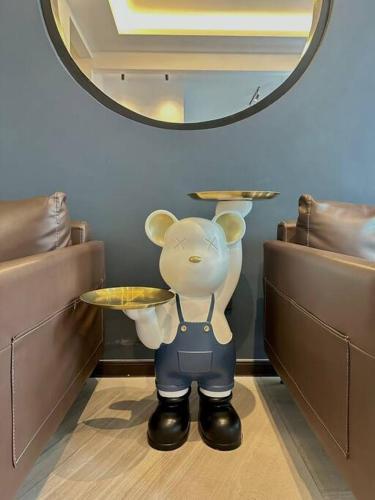 a teddy bear holding a table in front of a mirror at Ipoh 19A Villa for 12pax 6 Carpark with BBQ by IWH in Ipoh
