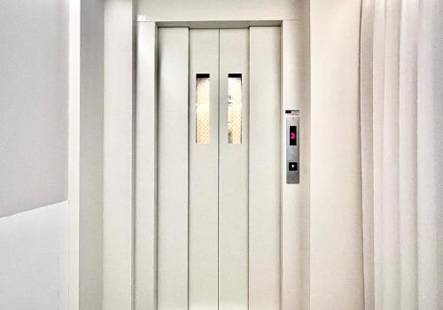 a white door with two windows in a room at 东京上野超级中心 设计师房间Yaoa 上野公园3分钟 车站1分钟 超级繁华 免费wifi 戴森吹风 in Tokyo