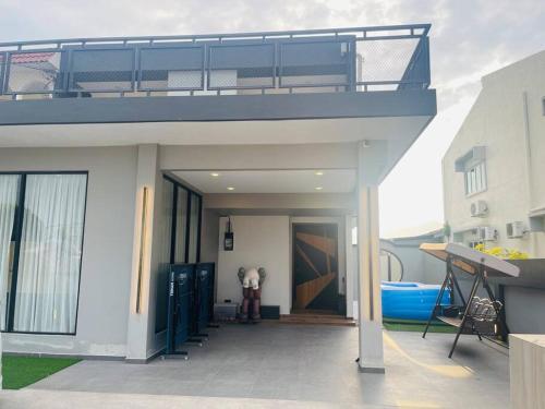 a person standing outside of a house with a balcony at Ipoh 19A Villa for 12pax 6 Carpark with BBQ by IWH in Ipoh
