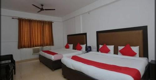 a hotel room with two beds with red pillows at Drive inn in Haridwār