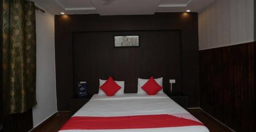 a bedroom with a bed with red pillows at Drive inn in Haridwār