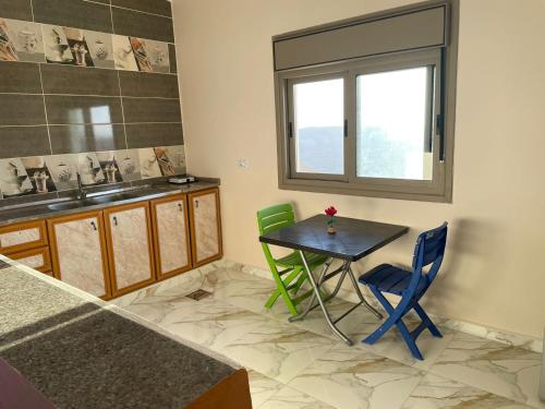 uma cozinha com mesa e cadeiras e uma janela em مزرعة الشفق em Ad Dimnah