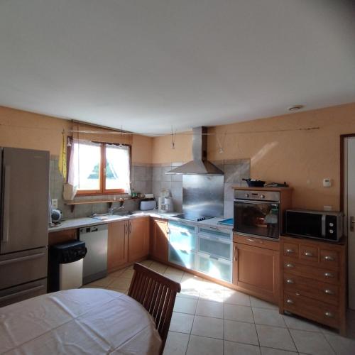 une cuisine avec un évier et une cuisinière four supérieur dans l'établissement Chalet Les Adrets du Sancy, à Saint-Diéry