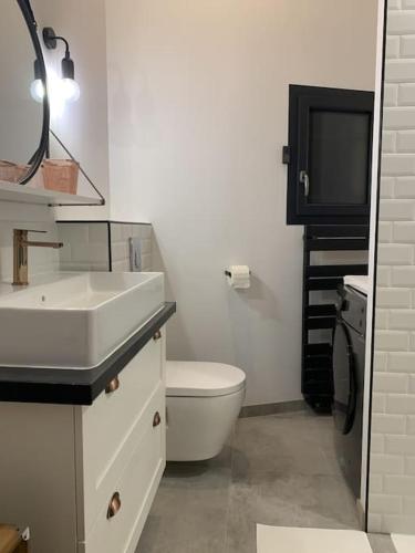 a bathroom with a sink and a toilet and a television at Cocon Classé 3 Etoiles - Love et Détente - SPA in Carpentras