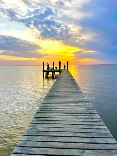 a wooden pier in the water with a sunset at The Spotted Tail in Hackberry