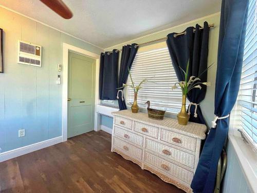 a room with a dresser and a window with plants at The Spotted Tail in Hackberry