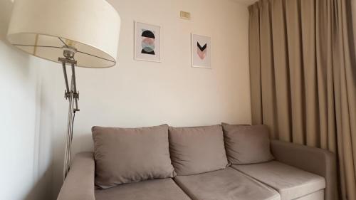 uma sala de estar com um sofá e um candeeiro em Departamento moderno en Rosario calidad & ubicación em Rosário