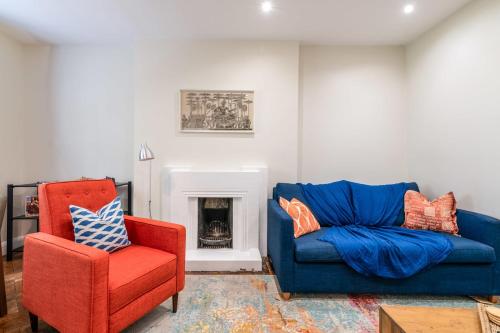 a living room with a blue couch and a red chair at Stylish Kings Cross Flat in London