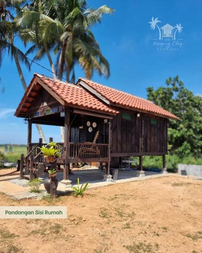 een klein huis met een dak op een strand bij Kampung Cheq Homestay - Private Pool, Free Wifi, Netflix in Penaga