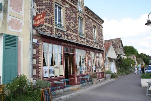a brick building with tables and chairs on a street at l'escapade in Gasny