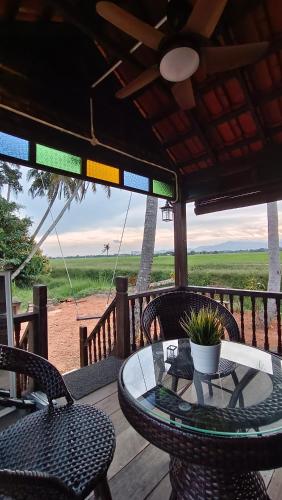 een terras met een tafel en stoelen bij Kampung Cheq Homestay - Private Pool, Free Wifi, Netflix in Penaga