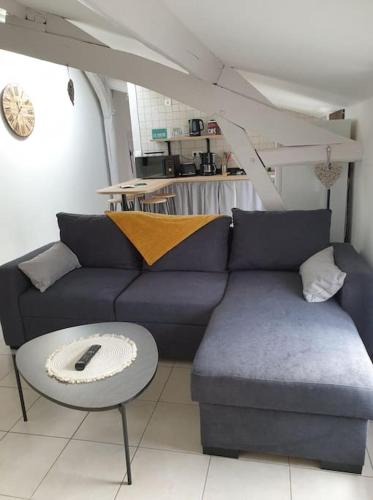 un salon avec un canapé bleu et une table dans l'établissement l'escapade, à Gasny