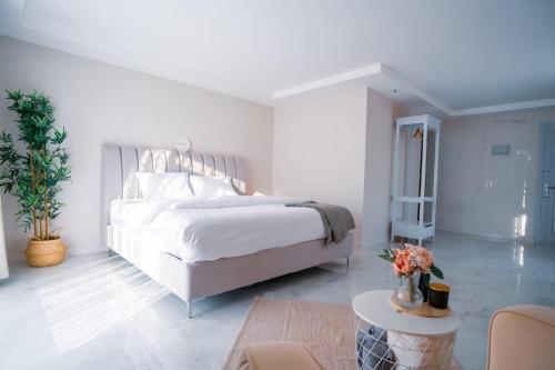 Dormitorio blanco con cama y mesa en Safari Desert Camp, en Shāhiq
