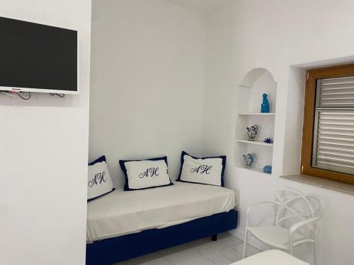 Habitación con cama con almohadas y TV. en Abagnale Home Sorrento en Sorrento