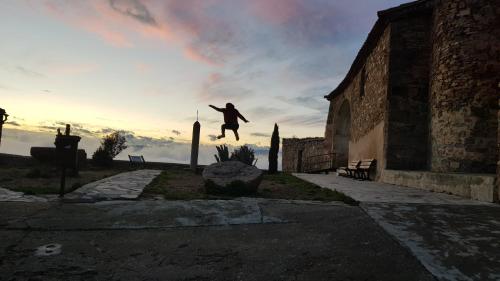 a person jumping in the air near a building at Las Abadías in San Felices