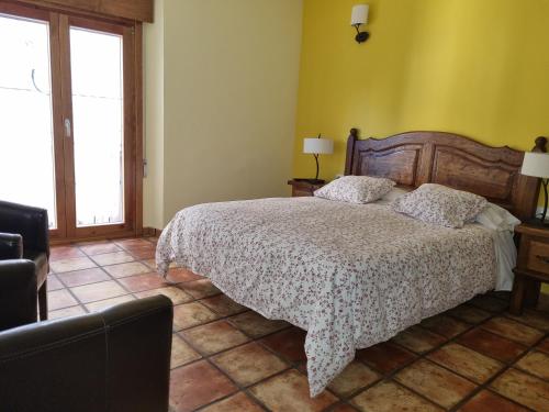 a bedroom with a bed in a room with yellow walls at Las Abadías in San Felices