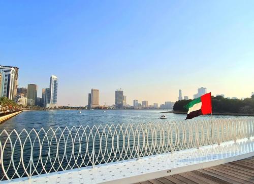 a flag on a fence next to a body of water at Holiday Home 2 Bedrooms Apartment for Family Only in Sharjah