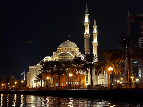 un gran edificio con una mezquita por la noche en Holiday Home 2 Bedrooms Apartment for Family Only, en Sharjah