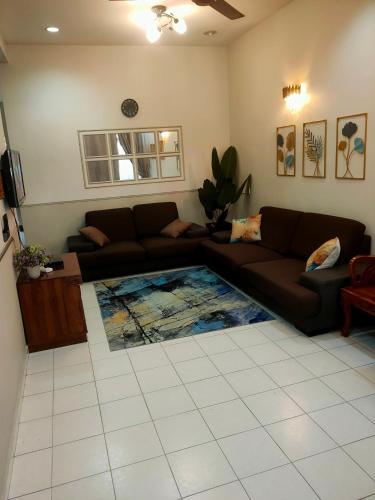 ein Wohnzimmer mit einem Sofa und einem Teppich in der Unterkunft Homestay 1 in Keluang