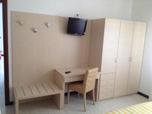 リド・ディ・イエゾロにあるApartment Istriaのデスク、壁掛けテレビが備わる小さな客室です。