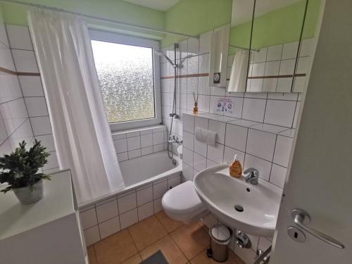 a bathroom with a sink and a toilet and a window at 1 room Apartment in Herscheid in Herscheid