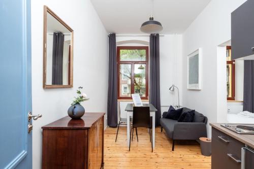 een keuken en een woonkamer met een tafel en een bank bij Künstlerzimmer im Kulturhaus Häselburg in Gera