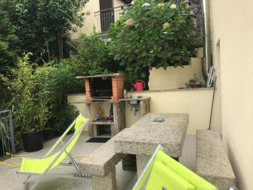 a patio with a table and chairs and a grill at Casa de Casarelhos - "Gerês" - Estúdio piso 0 - Apartamento Piso 1 in Geres