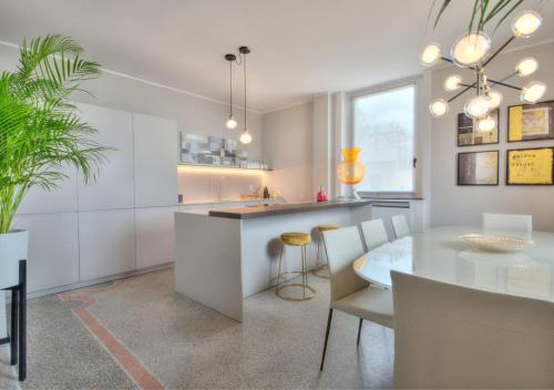eine weiße Küche mit einem Tisch und einem Esszimmer in der Unterkunft Livin' Portofino GOLD in Santa Margherita Ligure