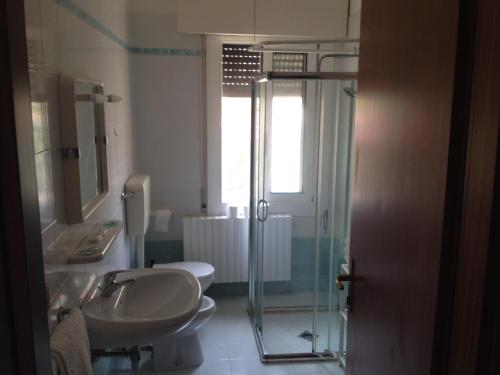 リド・ディ・イエゾロにあるApartment Istriaのバスルーム(洗面台2台、ガラス張りのシャワー付)